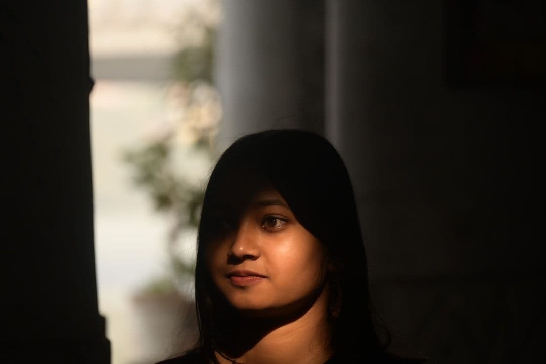 Ảnh minh hoạ — Young woman with dark hair in shadow